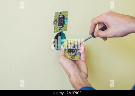 Electrician Installing Socket In New House. Electrician in the house Stock Photo