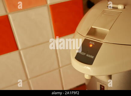 Closeup electric boiler pot in the kitchen under sunlight, focus on illuminated lamp of boil position, be angry concept Stock Photo