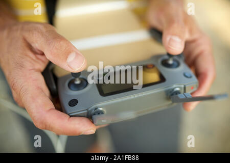 Close-up of a man driving the remote control of a drone. Stock Photo