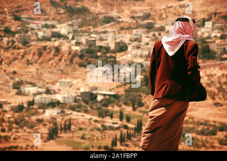 Jordanian man wearing  Arab traditional clothes in the top of the hill Stock Photo