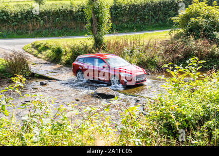 Exmoor National Park - A car crossing the ford over Badgworthy Water in the village of Malmsmead, Devon UK Stock Photo