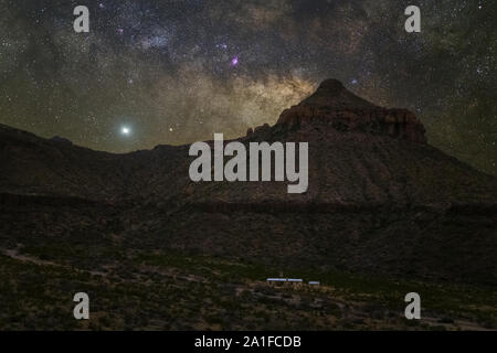 The Milky Way and Venus rise over Carousel Mountain and Homer Wilson Ranch in Big Bend National Park in Texas. Venus is the very big bright object in Stock Photo