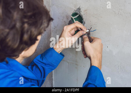 Electrician Installing Socket In New House. Electrician in the house Stock Photo