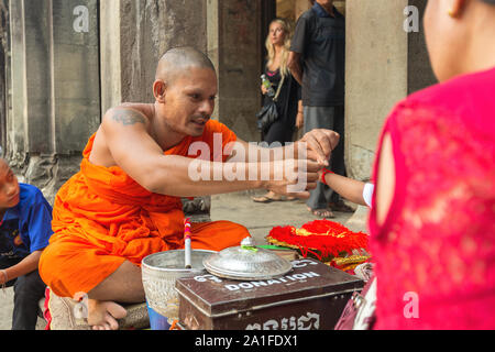 Siem Reap Cambodia January 30 2017 Buddhist monk ties the