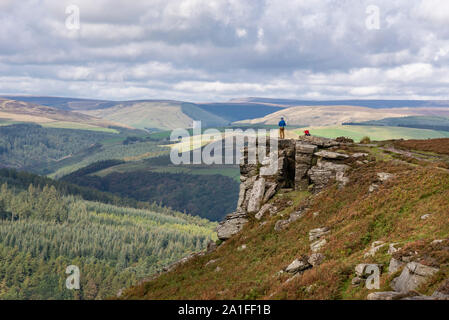 Sunny September day on Bamford Edge in the Peak District national park, Derbyshire, England. Rock climbers stood on the edge. Stock Photo