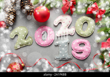 Colorful stitched digits 20 20 19 of polkadot fabric with Christmas decorations flat lay on stone background Stock Photo