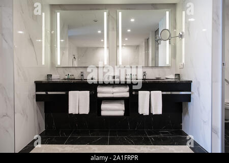 Modern twin bathroom with sinks, mirrors and towels. Stock Photo