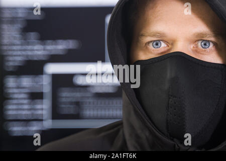 Hacker in black mask. Hacking and internet security concept. Stock Photo