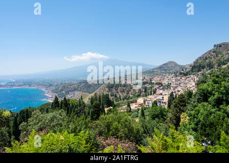 Beautiful view from Taormina, Sicily, Italy to Etna volcano and stunning blue bay of Villagonia. Smoke is coming out of the crater of the volcano. Stock Photo