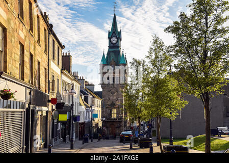 Shops and restaurants along a cobbled pedestrian street in a town centre at sunset Stock Photo