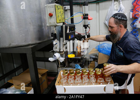 Tel Aviv, Israel. 26th Sep, 2019. A worker prepares honey at a honey shop in Kfar Chabad near Tel Aviv, Israel, on Sept. 26, 2019. Apples dipped in honey are traditionally eaten during the upcoming holiday of Rosh Hashanah, the Jewish New Year, which will start at sundown on Sunday. Credit: Gil Cohen Magen/Xinhua Stock Photo