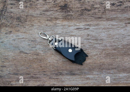 Leather keychain in Bat shape and old key in wooden door. - image Stock Photo