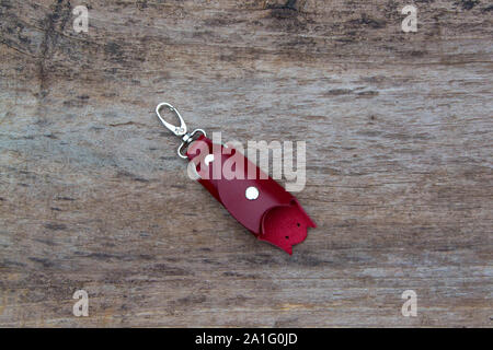 Leather keychain in Bat shape and old key in wooden door. - image Stock Photo