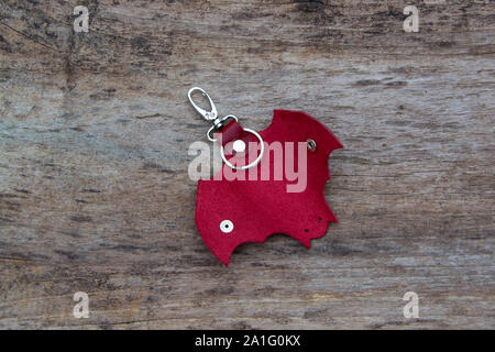 Leather keychain in Bat shape and old key in wooden door. - image Stock Photo