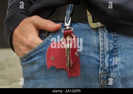 Leather keychain in Bat shape and old key in wooden door. - image Stock Photo