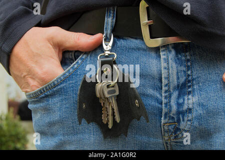 Leather keychain in Bat shape and old key in wooden door. - image Stock Photo