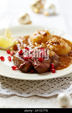 Roast beef with onion-mushroom sauce and pomegranate seeds for Christmas. Stock Photo