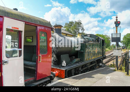 CRANMORE, ENGLAND - JULY 2019: Steam engine and train of carriages waiting at Cranmore Station on the East Somerset Railway. Stock Photo
