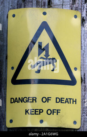 Old electrical warning sign on an electricity pole, Stock Photo