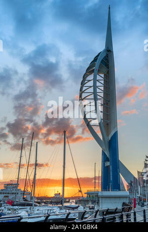 After a hot and humid day on the Hampshire coast, the lights come on at Gunwharf Quays as the sun sets over Portsmouth Harbour on the Solent and the f Stock Photo