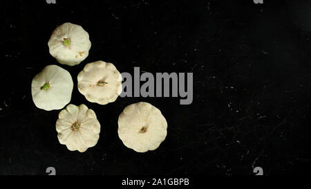 Five white pattypan squash heads on dark marble like board, wide banner with space for text right side Stock Photo