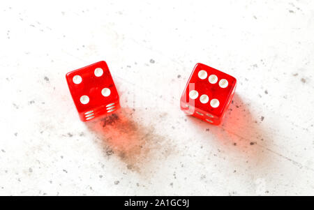 Two red craps dices showing Easy Ten number four and six overhead shot on white board Stock Photo
