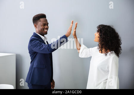 Businessman Giving High Five To His Colleague At Work Stock Photo
