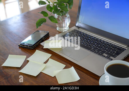 Wooden desk with laptop and many blank sticky notes, concept for business or the private home office, copy space, selected focus, narrow depth of fiel Stock Photo