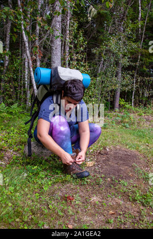 person sitting tying up the laces on their hiking boots ready for a walk Stock Photo
