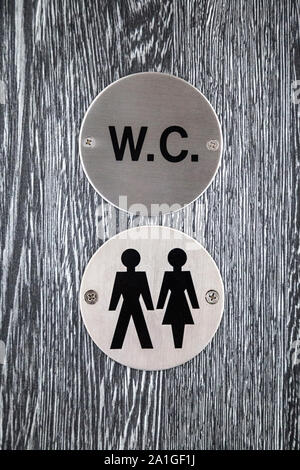 Sign for unisex toilet on a grey door Stock Photo
