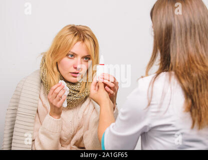 Girl in scarf hold tissue while doctor offer treatment. Cold and flu remedies. Recognize symptoms of cold. Remedies should help beat cold fast. Tips how to get rid of cold. Woman consult with doctor. Stock Photo