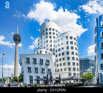 The Rheinturm tower and Neuer Zollhof Gerry Buildings at Düsseldorf Media Harbour spiraling and stretching into the sky in american architect Frank O. Stock Photo