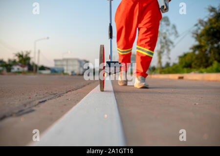 Measuring road distances with a measuring wheel Stock Photo