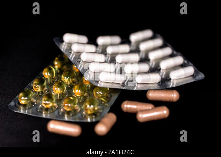 Isolated detail shot of different kinds of packaged and loose nondescript vitamins and supplement pills, Stock Photo