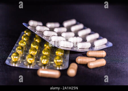 Isolated detail shot of different kinds of packaged and loose nondescript vitamins and supplement pills, Stock Photo