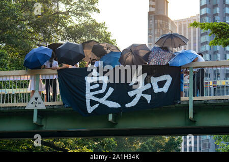 Wanchai, Hong Kong. 26 September, 2019. Human chain formed by students from local secondary schools in Hong Kong to support the pro democracy movement and anti-extradition bill. Banner meaning Conscience hung on bridge by school students Stock Photo