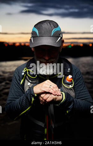 Portrait of athlete with grey beard and shadow on his eyes at night city background Stock Photo