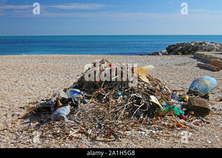 debris, rubbish or trash washed up on a beach in Numana near Ancona on the Adriatic coast in Italy with driftwood and plastic bottles polluting it Stock Photo