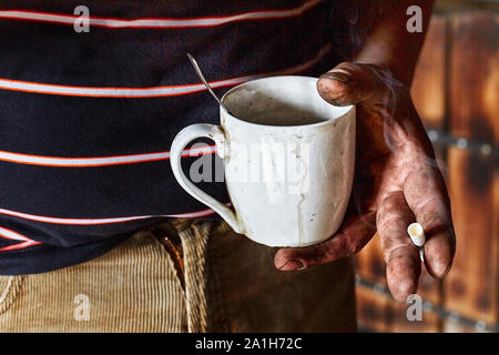Working miner holding a Cup with a drink Stock Photo