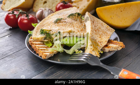 Ideas for a delicious breakfast. Omelet with broccoli on toasted bread. Mediterranean frittata cuisine. Cheese, cherry tomatoes, ice salad. Tasty and