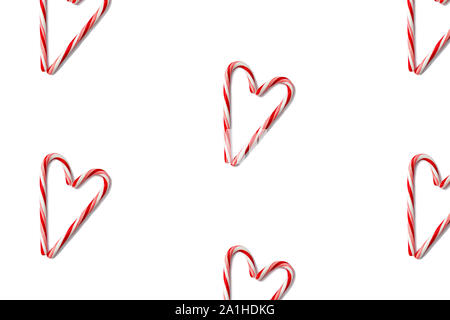 Candy canes shaped heart pattern isolated on white, top view. Stock Photo