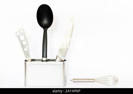 Assortment of kitchenware and cooking tools in a square silver colored metal box with copy space on white background Stock Photo