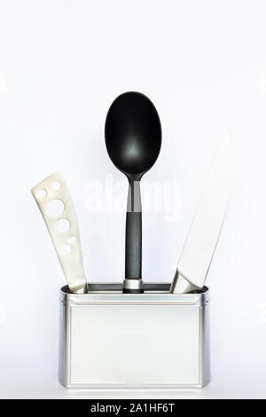 Assortment of kitchenware and cooking tools in a square silver colored metal box with copy space on white background Stock Photo