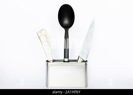Assortment of kitchenware and cooking tools in a square silver colored metal box with copy space on white background Stock Photo