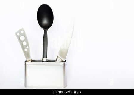 Assortment of kitchenware and cooking tools in a square silver colored metal box with copy space on white background Stock Photo