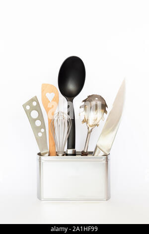 Assortment of kitchenware and cooking tools in a square silver colored metal box with copy space on white background Stock Photo