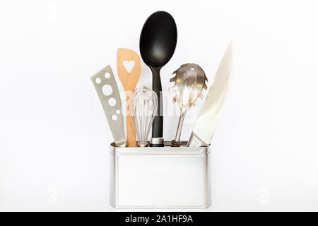 Assortment of kitchenware and cooking tools in a square silver colored metal box with copy space on white background Stock Photo