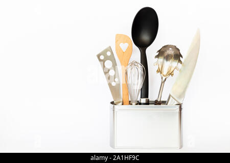 Assortment of kitchenware and cooking tools in a square silver colored metal box with copy space on white background Stock Photo
