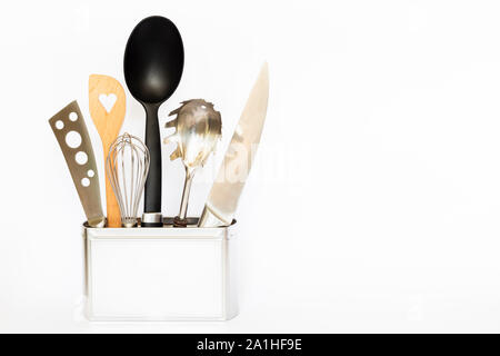 Assortment of kitchenware and cooking tools in a square silver colored metal box with copy space on white background Stock Photo