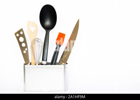 Assortment of kitchenware and cooking tools in a square silver colored metal box with copy space on white background Stock Photo